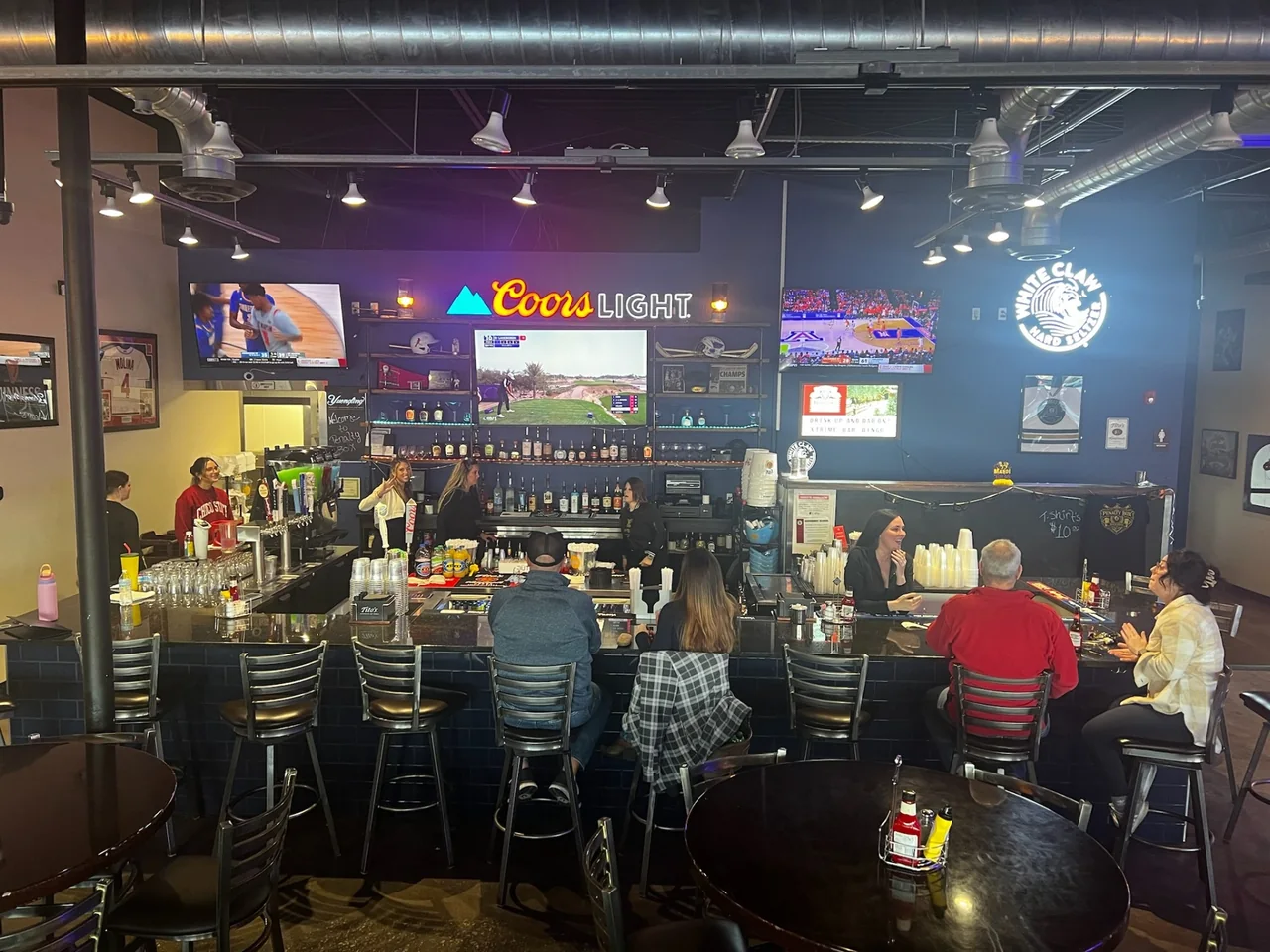Guests seated at the Penalty Box bar with televisions and tables in East Alton