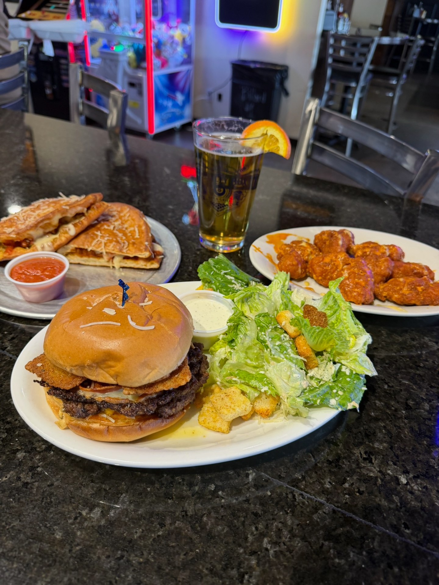 Penalty Box spread with a stacked double burger and Caesar salad, calzone with marinara, buffalo wings and a draft beer